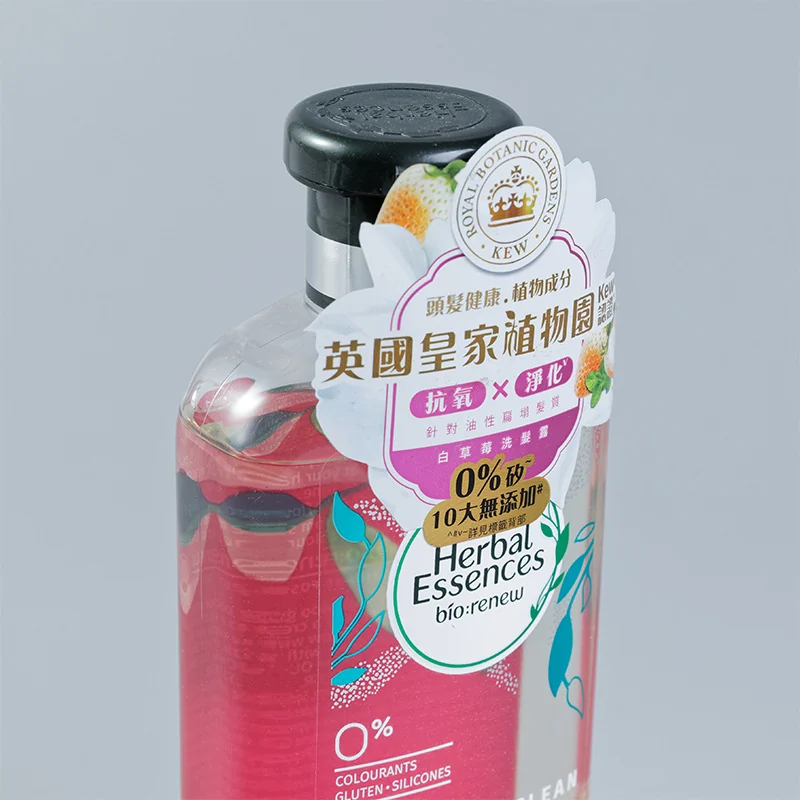 A partial-adhesive label applied across a personal-care bottle closure.